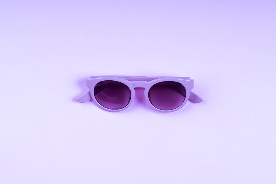 Ultra violet sun glasses on monochrome backdrop
